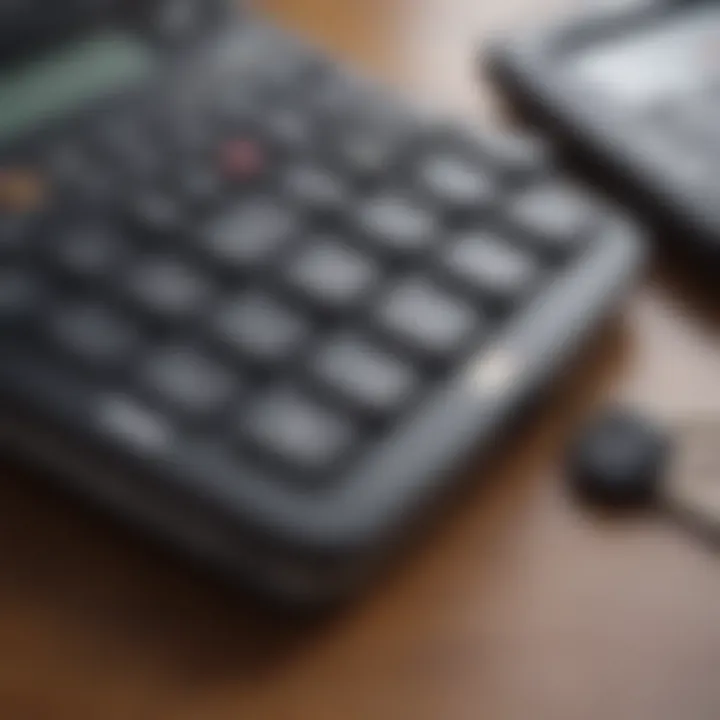 Close-up of a hand typing on a calculator with car keys beside it