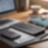 Close-up of a MacBook on a desk with a financial calculator and notebook